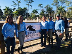 Keiser University students in front of an Equine Banner